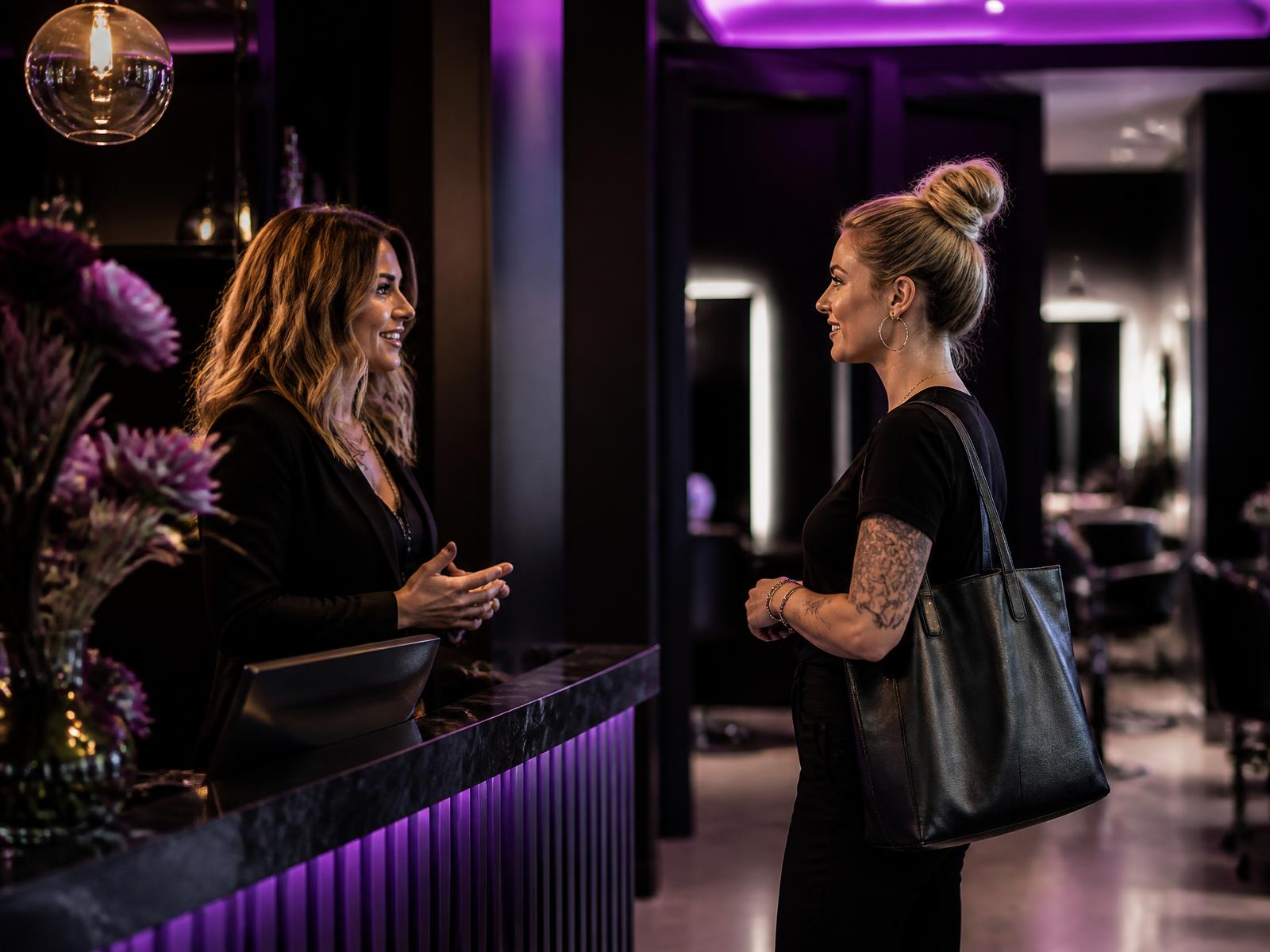 Salon suite operator talking with an independent beauty professional near reception